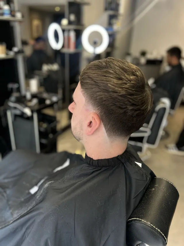A fresh taper cut at Noahs Barbers, with the shop's ring lights and chairs behind